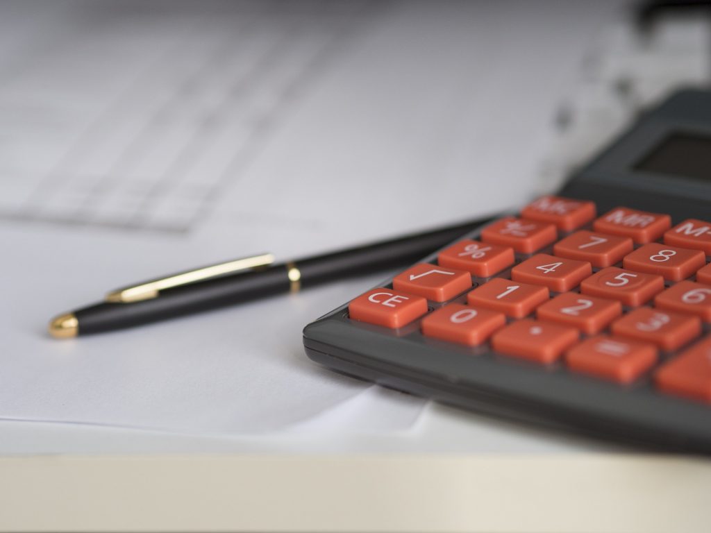 calculadora, papel e caneta para administrar a carteira de investimentos