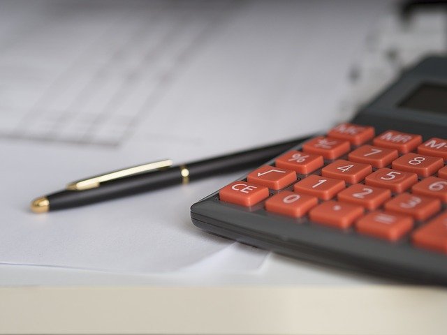 calculadora e caneta para realizar um comprovante de renda autônomo